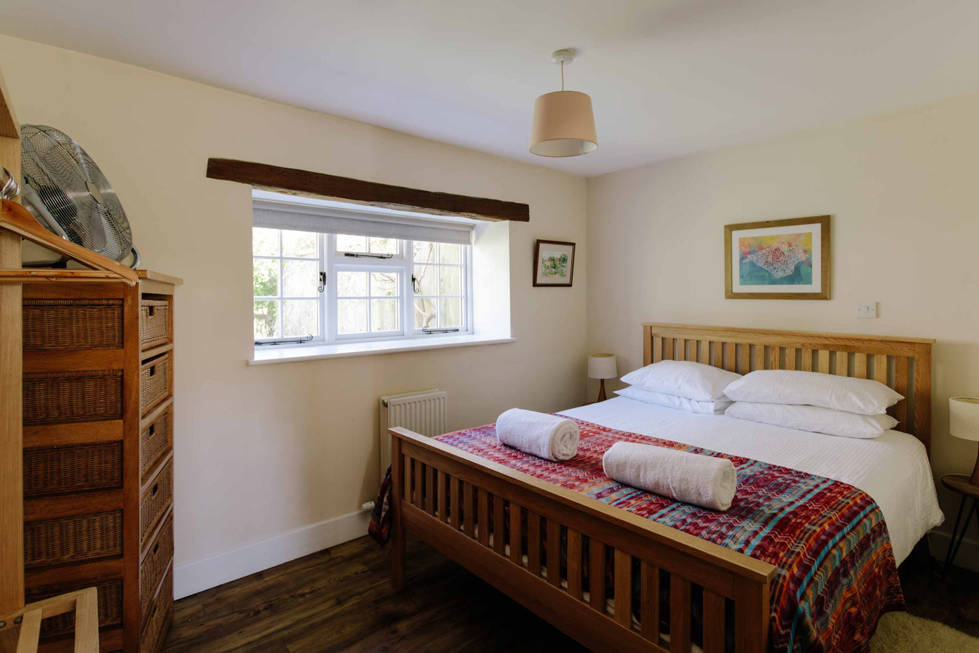 Bedroom with wooden bed, dresser, and window